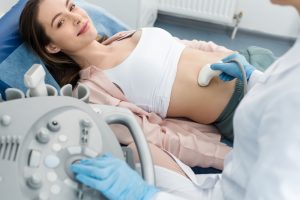 A woman is having a private ultrasound in London. The sonographer is taking images of her abdomen