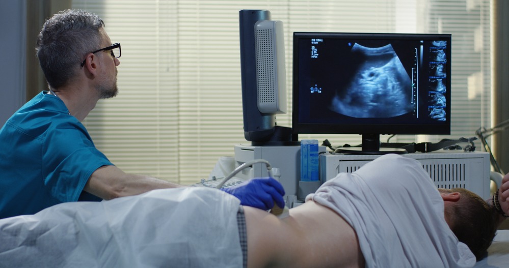 A man is having a private ultrasound in London. The sonographer is looking at ultrasound images on the screen